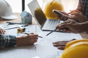 Construction project planning and estimating with laptop, blueprints, and tools.