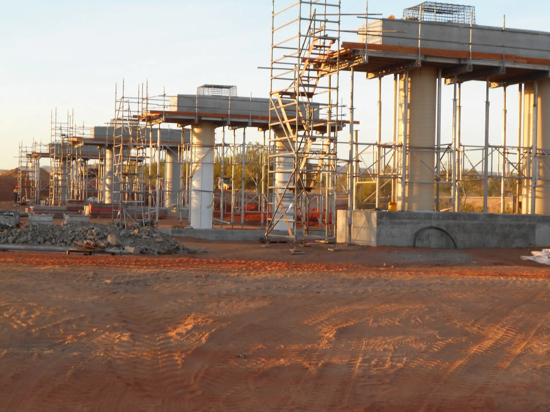 Concrete building structure under construction with scaffolding and support columns at a construction site