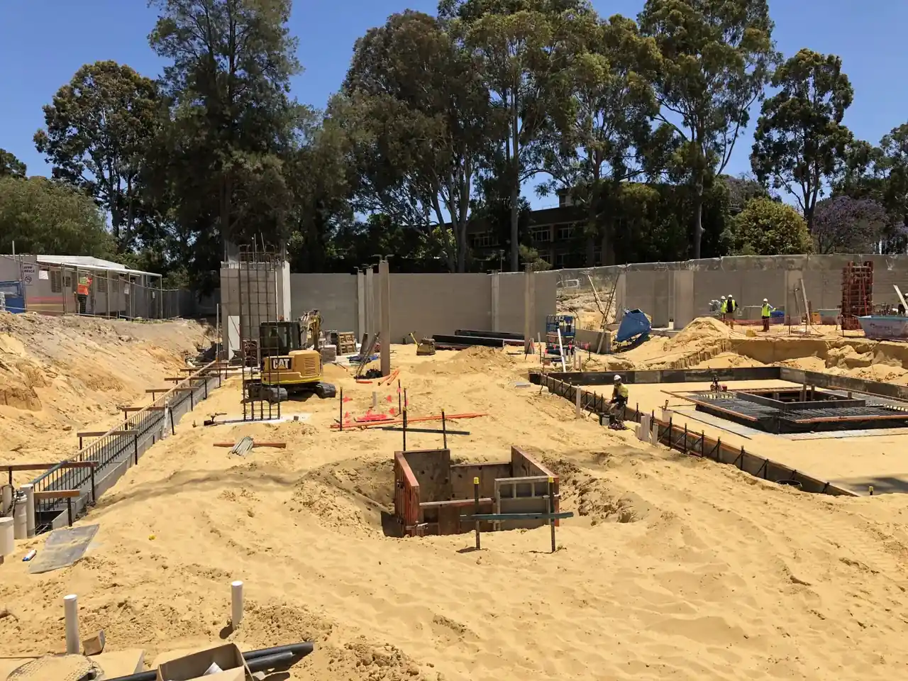 Concrete building structure under construction with scaffolding and support columns at a construction site